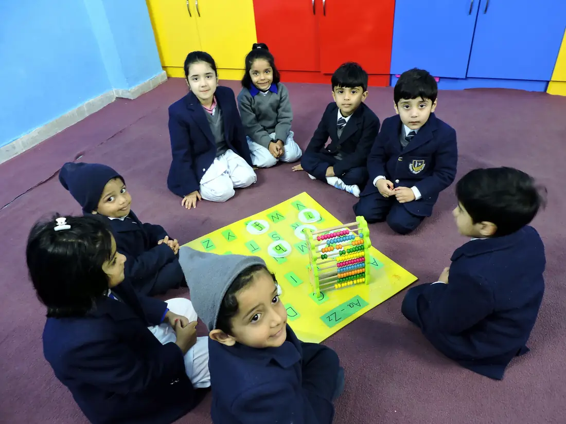 Pre-School children sitting in a circle with an abacus